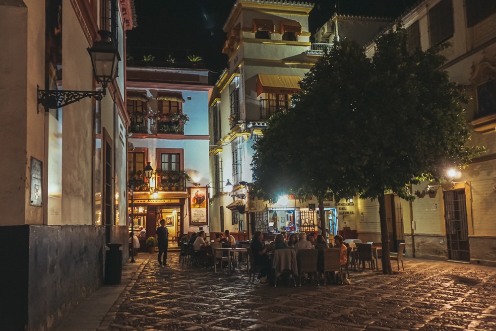 Nocny skwer z otwartą knajpą w Barrio de Santa Cruz